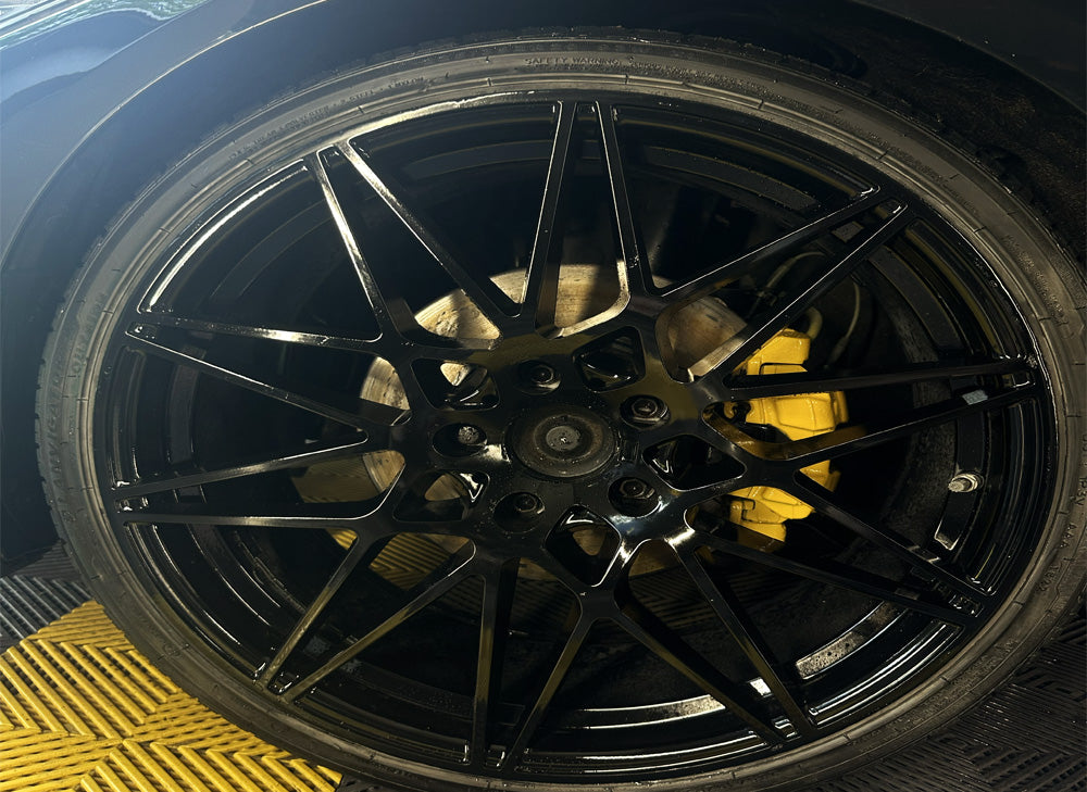 Black alloy wheel with a yellow brake caliper