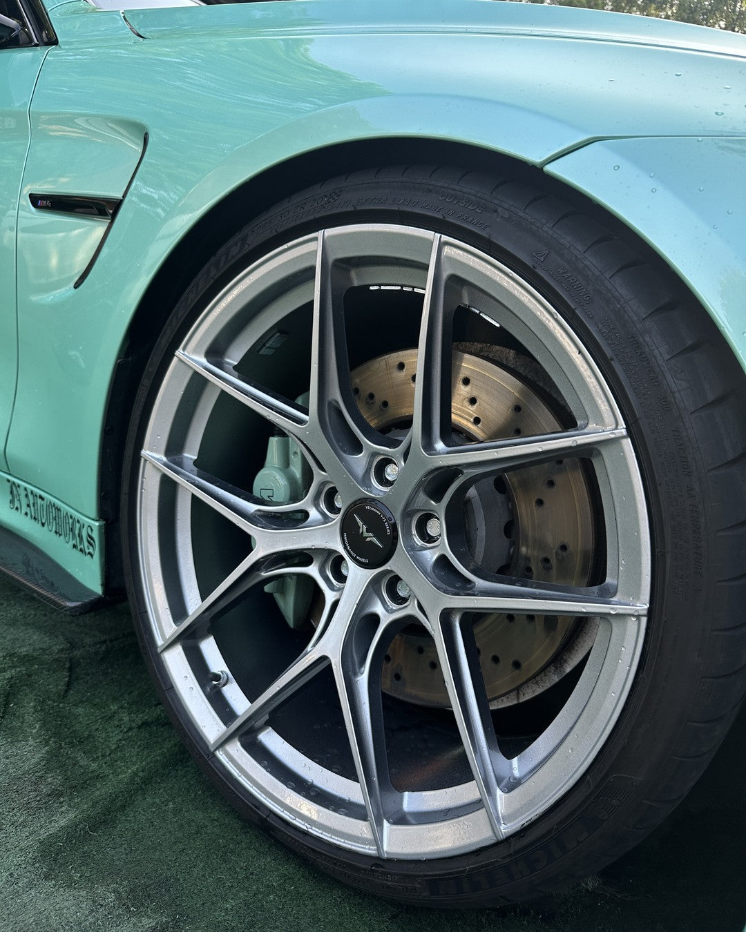 Close-up of a refurbished silver multi-spoke alloy wheel and brake on a mint green BMW, Vantom, Congleton